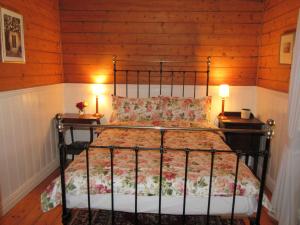 - une chambre avec un lit en métal et 2 tables de chevet dans l'établissement Nivani 1880's cottage, à Port Fairy