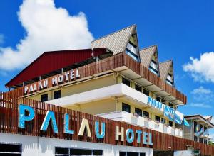 a hotel with a sign on top of it at Palau Hotel in Koror