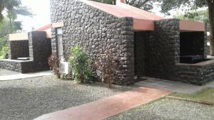 una casa in pietra con un muro di pietra di Hotel Kailas a Ellora