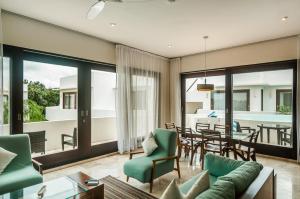 a living room with a table and a dining room at Mak Nuk Village - Clothing Optional in Tulum