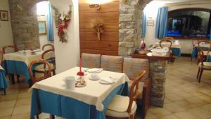 a restaurant with two tables with blue and white table cloth at Hotel Triolet in Courmayeur