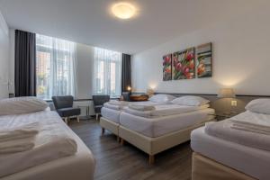 a room with a bunch of beds in it at Hotel Randenbroek in Amersfoort
