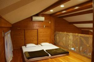 une chambre avec deux lits dans une pièce aux murs en bois dans l'établissement Karin Design Cottage, à Onna