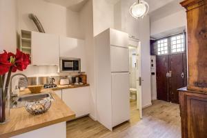 ローマにあるRhome Apartments Candiaの白いキャビネットとシンク付きのキッチン