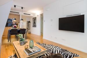 ein Wohnzimmer mit einem TV und einem Zebra-Teppich in der Unterkunft Rafael Kaiser - Premium Apartments City Centre - Contactless 24h Check-In in Wien