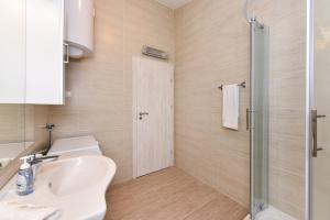 ein Bad mit einem Waschbecken und einer Dusche in der Unterkunft Apartments Ana Vrsi in Vrsi