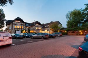 a parking lot with cars parked in front of a building at Hotel Restaurant Bullerdieck in Garbsen