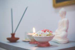 a table with a bowl of flowers and a candle at Lazies Midigama in Midigama East