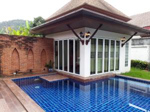 a pavilion over a swimming pool in a house at BaanManchusa Thai Villa in Rawai Beach
