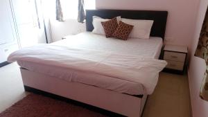 ein Schlafzimmer mit einem großen Bett mit weißer Bettwäsche und Kissen in der Unterkunft Tranquil Hospitality in Bhubaneshwar