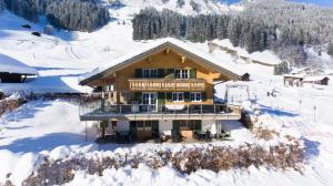 ein Haus auf einem schneebedeckten Berg in der Unterkunft Ferienwohnungen Kohler komplett neu renoviert !!!!! in Mittelberg