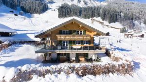 a house on top of a snow covered mountain at Ferienwohnungen Kohler komplett neu renoviert !!!!! in Mittelberg