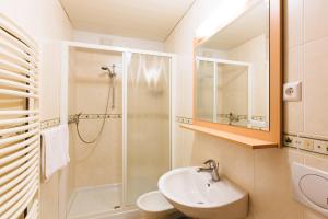 a white bathroom with a sink and a shower at Apartments Dolar in Bled +4 photos