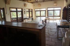 een proefruimte met houten tafels en ramen bij Masaka Backpackers, Tourists Cottage & Campsite in Masaka