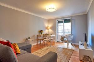 - un salon avec un canapé et une table dans l'établissement Charming Apartment in Alfama, à Lisbonne
