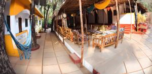 a porch of a building with benches and a canopy at Dreams Hostel in Vagator