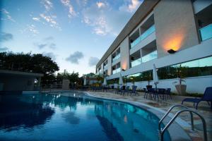 a large swimming pool in front of a building at Cricaré Praia Hotel in Conceição da Barra