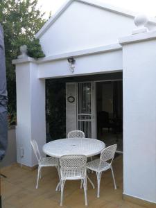a white table and chairs on a patio at At 98 on Lynburn Guest House in Pretoria