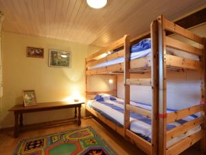 Comfortable cottage near Lake Cherapont في Limerlé: غرفة نوم بسريرين بطابقين وطاولة