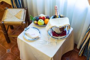 una mesa con un bol de fruta y una botella de vino en Cortijo De Tajar, en Huétor-Tájar