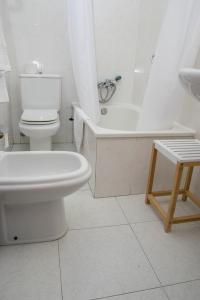 a white toilet sitting next to a bath tub at Hotel Brisa in A Coruña