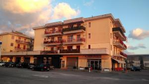 Un grand bâtiment avec des voitures garées dans un parking dans l'établissement Costa d'Amalfi e Cilento, à Pontecagnano