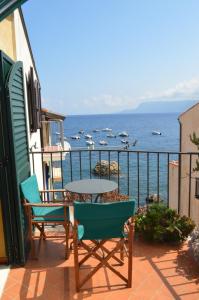 a balcony with a table and chairs and the ocean at Le Piccole Grotte in Scilla