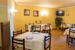 a dining room with tables and chairs and a tv at Hotel Brisa in A Coruña