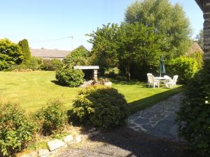 a garden with a table and chairs and a gazebo at Gite De Penn Ar Stank in Pont-de-Buis