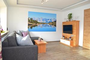 sala de estar con sofá y TV en Chalet Hoamat, en Mariapfarr