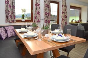 a wooden table with plates and glasses on it at Chalet Hoamat in Mariapfarr