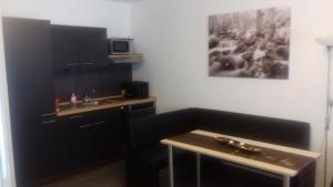 a kitchen with black cabinets and a sink and a microwave at Wietheger´s Ferienwohnungen Gästehaus Strycktal II in Willingen