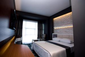 a bedroom with a bed and a brick wall at Aripsas Hotel in Giresun