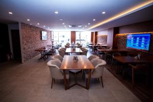 a restaurant with tables and chairs and a large screen at Aripsas Hotel in Giresun