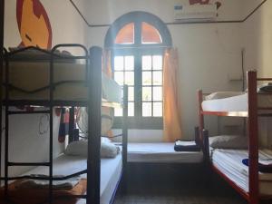 a room with three bunk beds and a window at Rivera Hostel Córdoba in Cordoba