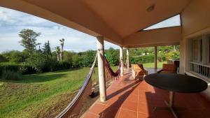 a porch with a hammock and a view of a yard at casa de campo en Villa Los Aromos Cordoba in Villa Los Aromos