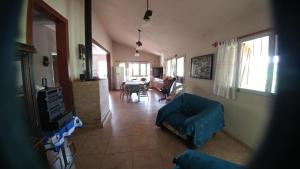 a living room with a blue couch and a table at casa de campo en Villa Los Aromos Cordoba in Villa Los Aromos