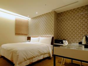 a hotel room with a bed and a phone at Hotel Puri Taipei Station Branch in Taipei