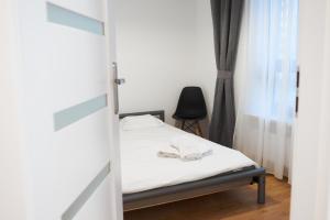 ein Schlafzimmer mit einem Bett, einem Stuhl und einem Fenster in der Unterkunft NotaBene Apartment in Warschau