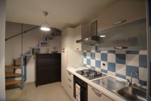uma cozinha com um lavatório, um fogão e uma escadaria em Suite del Borgo em Taranto