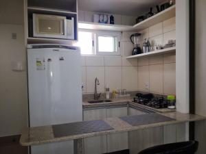 cocina con nevera blanca y microondas en Apple Flat, en Natal