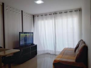 sala de estar con TV y sofá en Apple Flat, en Natal