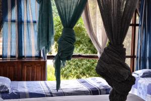 2 letti in una camera con finestra di Lobo Hostel - Rurrenabaque a Rurrenabaque