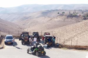 Un groupe de personnes debout à côté de leur voiture sur une montagne dans l'établissement Yehelim Boutique Hotel, à Arad