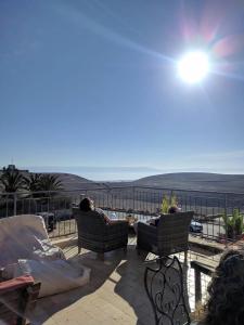 Dos personas sentadas en sillas en un patio con vistas al océano en Yehelim Boutique Hotel en Arad