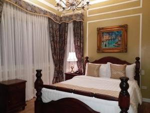 1 dormitorio con cama y lámpara de araña en Lee Boutique Hotel Tagaytay, en Tagaytay