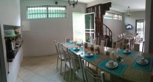 uma cozinha com mesa e cadeiras num quarto em Pousada Casagrande - São João em Volta Redonda