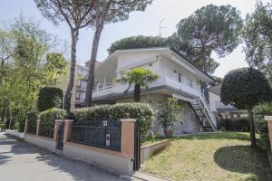 a white house with a fence in front of it at Appartamenti Federica in Milano Marittima