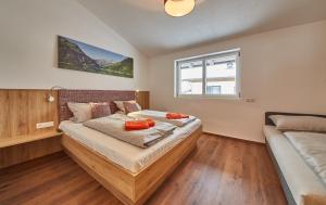a bedroom with a bed with orange pillows on it at Holiday Penthouse Moosweg in Maishofen