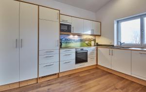 een keuken met witte kasten en een raam bij Holiday Penthouse Moosweg in Maishofen